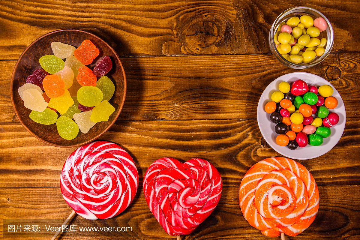 不同的糖果放在一张木桌上。俯视图